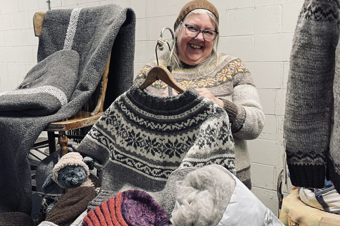 Tracy at her market stall with her very own knitwear, sweaters, hats and yarn.